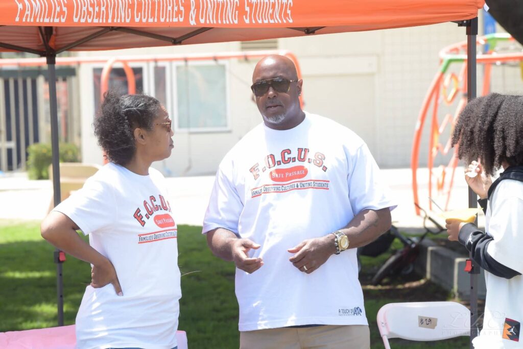 Community members visiting the F.O.C.U.S. Safe Passage booth during Juneteenth 2025